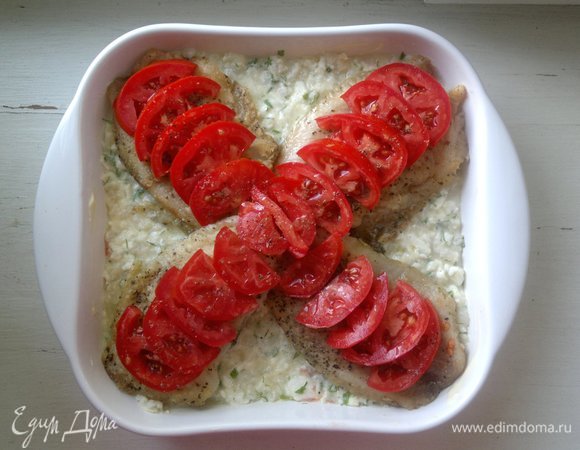 Выложить помидоры на рыбу, сбрызнуть оставшимся растительным маслом. Поставить форму в духовку, разогретую до 180°C, на 20–25 минут.