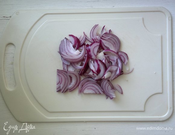 Лук почистить, разрезать вдоль пополам и нарезать ломтиками.
