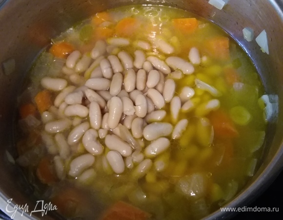 Добавить 3/4 количества фасоли. Фасоль можно использовать консервированную или отварить заранее. Влить 0,5 литра воды и протертые помидоры.