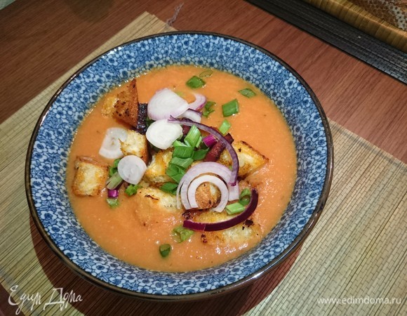 Перед подачей обжарить на небольшом количестве оливкового масла нарезанную колбаску (вместо чоризо можно использовать любую пикантную колбасу на ваш выбор). К чоризо выложить нарезанный на кубики багет и обжарить до золотистого цвета. Нарезать кольцами зеленый лук. Горячий суп разлить по тарелкам, добавить колбаски с гренками, украсить зеленым луком. Приятного аппетита!