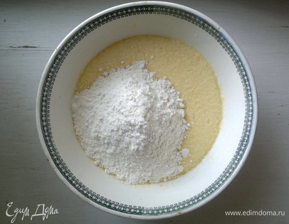 Соединить просеянную муку и разрыхлитель. Постепенно всыпать сухую смесь в масляно-яичную, взбить.