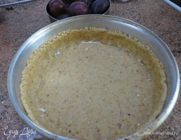 Включите духовку на разогрев до 220°C. Подготовьте разъемную форму диаметром 23–24 см: дно застелите пекарской бумагой, бока можно не смазывать, так как песочное тесто достаточно жирное. Две трети остывшего теста выложите на дно, а из остального сформируйте бортики высотой 5 см. Тесто на дне в нескольких местах проколите вилкой. Выпекайте 20–25 минут. Тесто должно полностью пропечься и приобрести золотистый цвет. Бока немного осядут. Готовую основу оставьте в форме даже после полного остывания.