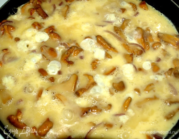 Залить грибы подготовленной яичной смесью. Закрываем сковороду крышкой и готовим омлет на среднем огне, пока он не станет мягким и кремообразным.