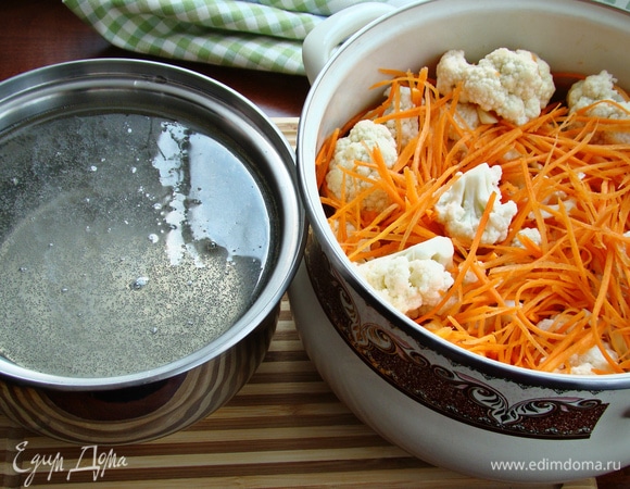 Смешать в кастрюле капусту, морковь и чеснок. В отдельном сотейнике вскипятить маринад из воды, уксуса, соли, сахара и растительного масла и горячим залить капусту.