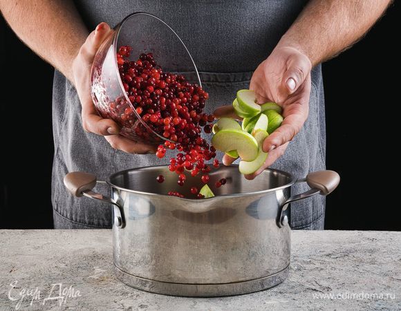 В кастрюле соедините нарезанные дольками яблоки и бруснику.