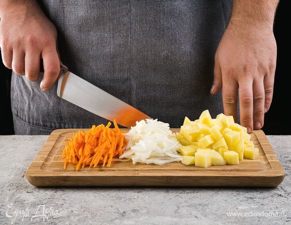 Картофель почистите и нарежьте на небольшие кубики, лук мелко нарежьте, морковь нарежьте тонкой соломкой.