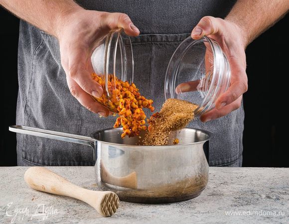 В сотейнике смешайте облепиху и сахар, разомните.