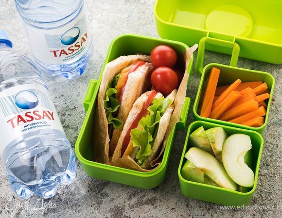 Положите сэндвичи в контейнер, добавьте бутылку негазированной воды Tassay и контейнеры с морковными палочками и кусочками яблок — питательная и сытная ссобой для ребенка готова!