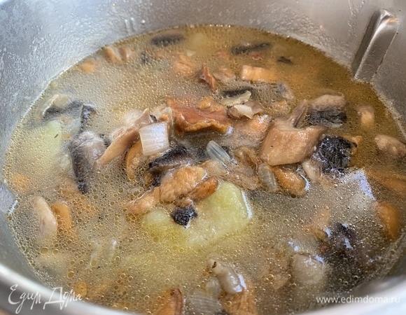 Добавьте грибы к готовому картофелю и доведите до кипения.