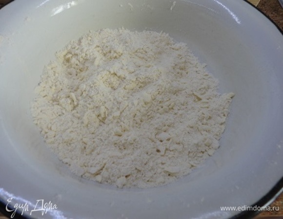 Можно приготовить его в кухонном комбайне, а если нет такового, как у меня, то смешайте муку с солью и разрыхлителем и натрите на крупной терке холодное масло. Перетрите руками в крошку. Добавьте яичный желток и при необходимости — холодную воду (может, вся не понадобится), замесите тесто. Включите духовку на разогрев до 200°C.