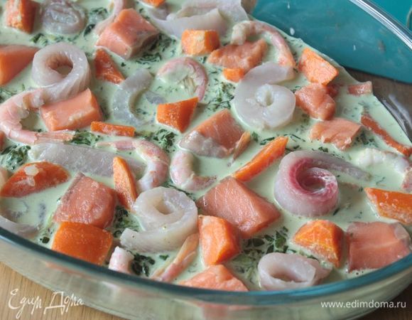 Отдельно отварите морковь до полуготовности и нарежьте небольшими кусочками. По желанию можно заменить морковь помидорами: их нужно будет нарезать дольками и оставить только мякоть, удалив семена с жидкостью. В форму для выпечки переложите шпинатный карри-соус. В соус в свободном порядке выложите лосось, филе тилапии (я его скручиваю в розочки) и креветки. Добавьте полуготовую морковь.