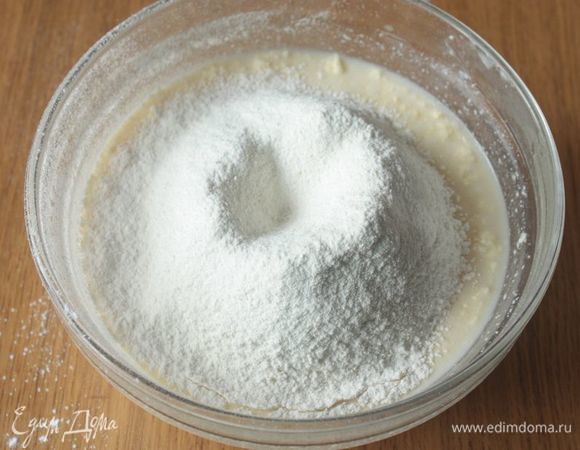 Влейте в тесто теплое молоко и просейте муку. Замесите гладкое тесто.