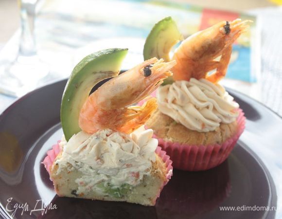 Оставшийся сливочный сыр выложите в кондитерский мешок и украсьте кексы сырной шапочкой. Отложенные креветки обжарьте на оливковом масле и также украсьте кексы ими и кусочками авокадо. Готовые кексы подавайте к столу. Приятного аппетита!