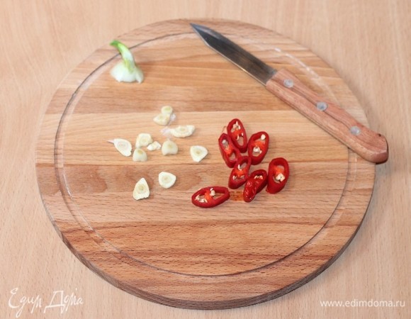 Чеснок нарезаем тонкими пластинами. Перец чили — дольками. На разогретом растительном масле обжариваем чеснок и острый перец до появления аромата. Затем овощи удаляем, масло оставляем.