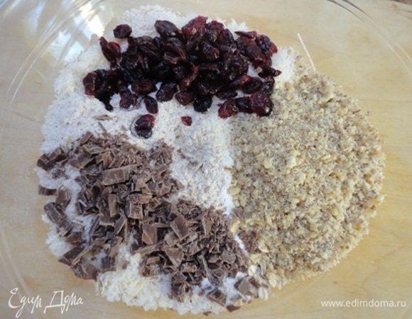 Добавить их вместе с клюквой к муке с хлопьями и вновь перемешать.