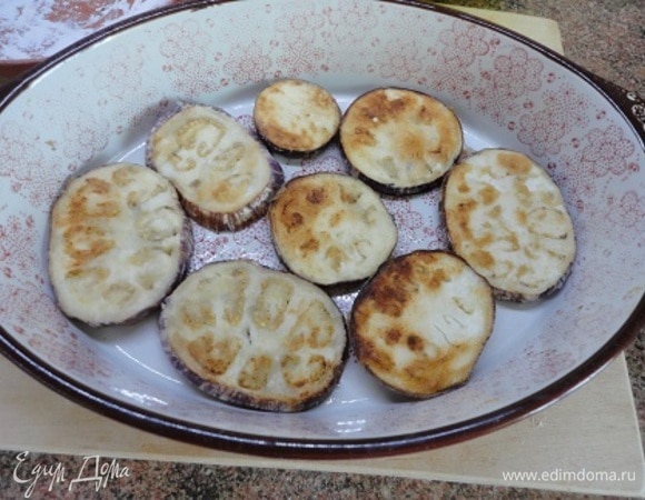 Обжаренные баклажаны слоем выложить в форму для запекания.