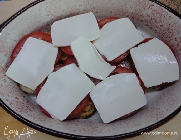 Часть брынзы нарезать пластинами и уложить на помидоры. Затем повторить слой баклажанов и помидоров.