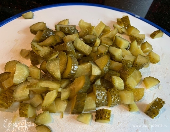 Соленые огурцы нарежьте маленькими кусочками.