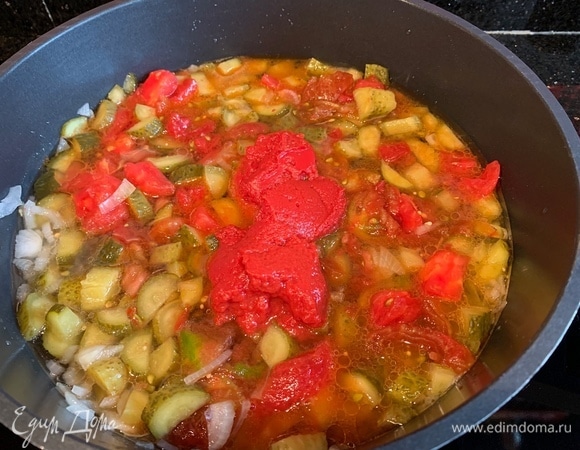 Разогрейте оливковое масло на сковороде и обжарьте лук. Добавьте соленые огурцы, помидоры, томатную пасту, влейте огуречный рассол и тушите 10 минут на медленном огне.