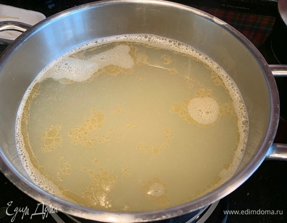 Процедите бульон через два слоя марли в чистую кастрюлю. Добавьте лук с огурцами и томатами, доведите до кипения и варите 10 минут.