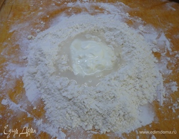 Добавить сметану, 50 мл ледяной воды и быстро замесить тесто. Завернуть его в пищевую пленку и положить в холодильник на 1 час.