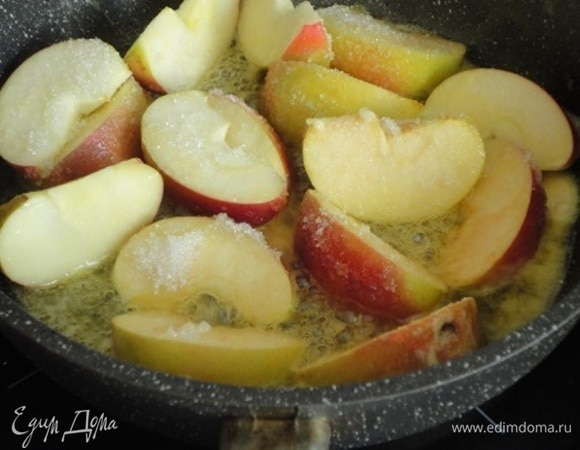 Яблоки вымыть, разрезать каждое на 8 долек и удалить сердцевину с семенами. На сковороде растопить оставшееся сливочное масло, положить туда яблоки, посыпать сахаром и при постоянном помешивании жарить на сильном огне 10 минут.