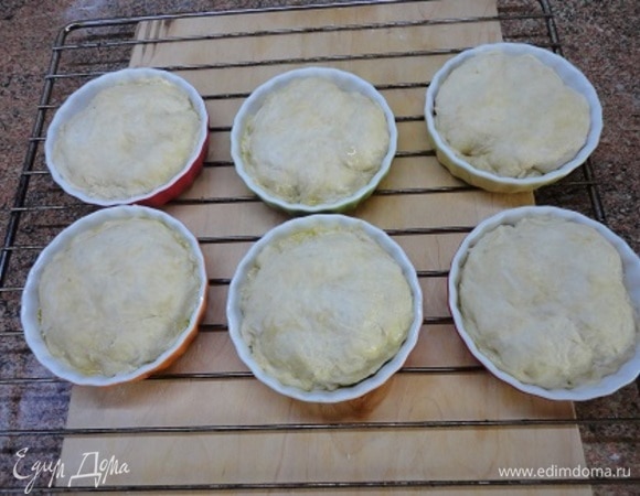 Тесто разделить на 6 частей, каждую раскатать в кружочек и накрыть кружочками формочки с яблоками, подвернув края внутрь.