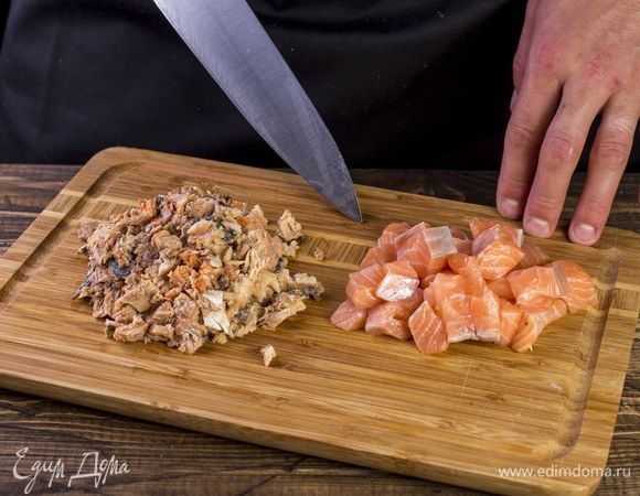 С горбуши слейте жидкость, удалите большие косточки, порубите. Кубиками нарежьте лосось.