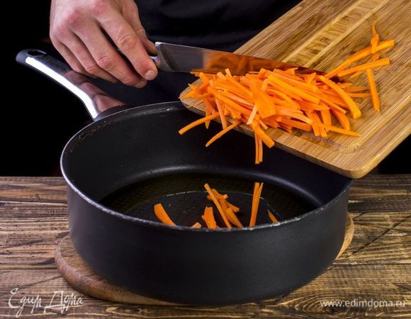 Морковь нарежьте соломкой. Налейте в сотейник масло и выложите морковь. Немного обжарьте.