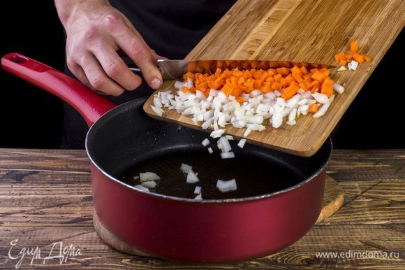 В сковороду налейте масло и выложите лук и морковь. Пожарьте до золотистого цвета.