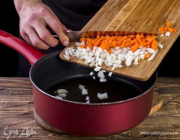 В сковороду налейте масло и выложите лук и морковь. Пожарьте до золотистого цвета.