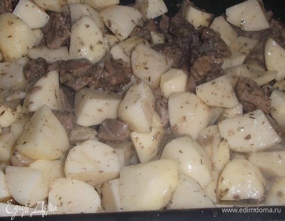 Выложить мясо к картофелю. Добавить натертый на крупной терке чеснок и еще раз все хорошо перемешать.