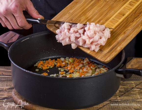 Выложите курицу к овощам, пожарьте ее 5 минут.