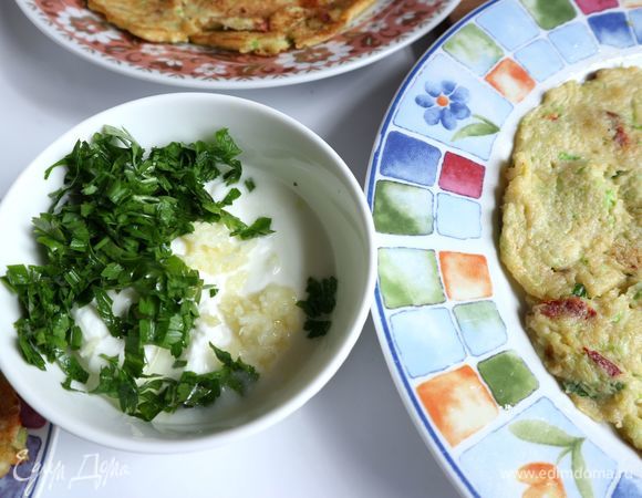 Сковороду разогреть, добавить оливковое масло, обжарить кабачковый блин с двух сторон до румяной корочки. У меня получилось четыре блина. В йогурт добавить чеснок, измельченную зелень петрушки (1 веточка), перемешать.