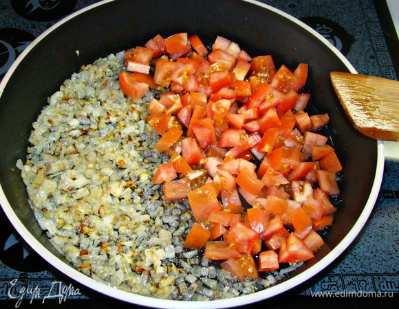 В глубокой сковороде обжарить на растительном масле нашинкованный репчатый лук. К луку добавить мелко нашинкованные помидоры и измельченный чеснок. Все перемешать и обжарить. Если у помидоров грубая кожица, то ее необходимо снять, предварительно ошпарив томаты кипятком.