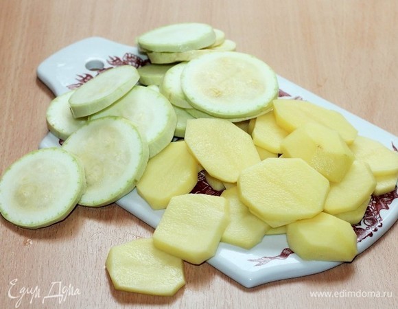 Картофель очищаем. Кабачок и картофель нарезаем кружочками и бланшируем в кипящей подсоленной воде до полуготовности.