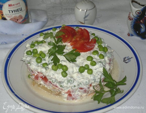 При подаче украсить салат оставшимся зеленым горошком, дольками помидора и веточками любой зелени.