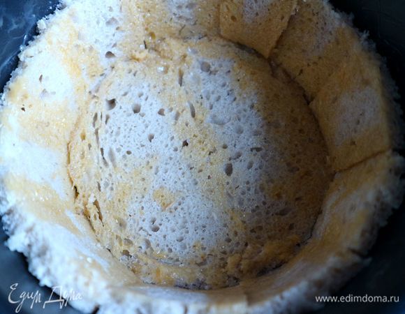 Обложить борта формы кусочками хлеба стык в стык. Дно формы, покрытое бумагой для выпечки, выложить кусочками хлеба без корки. Яичный желток смешать с молоком. Кисточкой нанести эту смесь на стыковочные швы между кусочками хлеба. Духовку разогреть до 190°C.