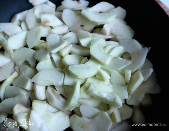 Яблоки очистить от кожуры, разрезать пополам, удалить семенную часть. Нарезать тонкими дольками, сбрызнуть лимонным соком. Выложить их на сковороду.