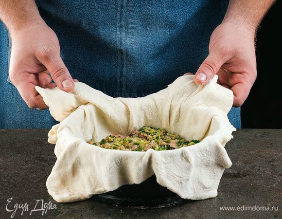 Раскатайте тесто и расстелите его в форме. Выложите начинку и аккуратно заверните края. Запекайте до полуготовности.