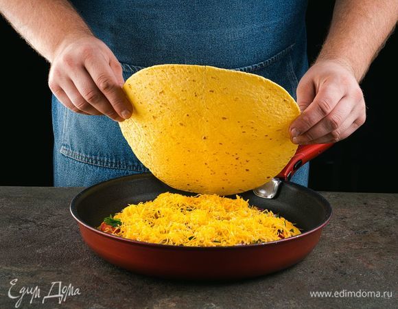 Посыпьте оставшимся тертым сыром. Накройте второй лепешкой.