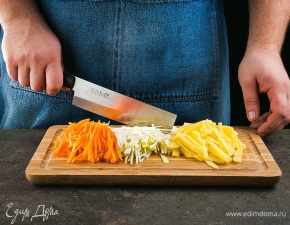 Почистите морковь и картофель, нарежьте соломкой. Лук-порей нарежьте кружочками.