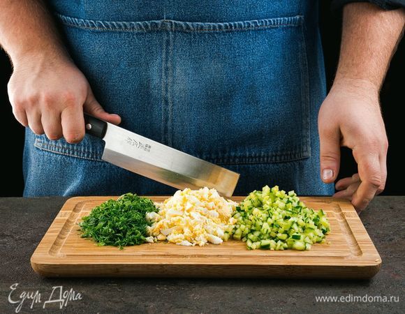 Отварите яйца. Мелко нарежьте яйца, огурец, зелень.