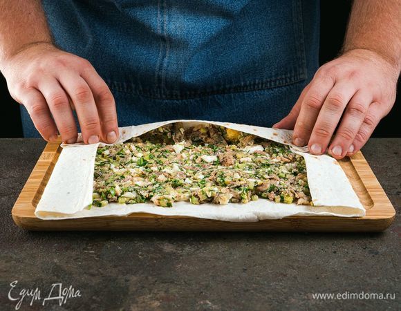 На лист лаваша выложите начинку. Сверните рулет.