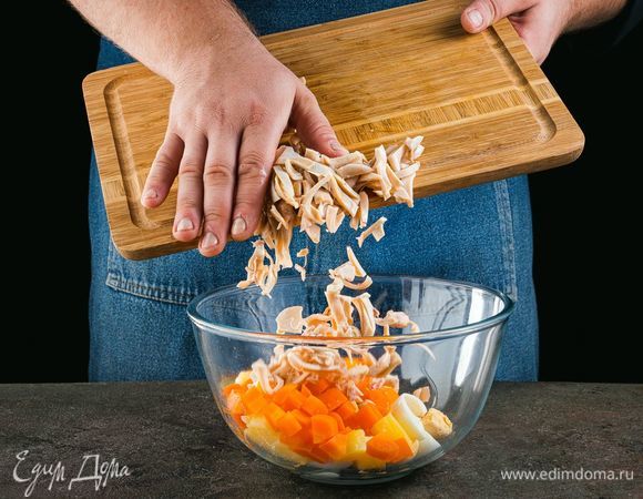 Смешайте в салатнике отваренные овощи, кальмары и яйца.