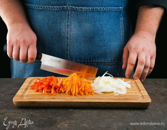 Изюм промойте и залейте кипятком. Оставьте его на 30 минут. Лук, морковь и перец нарежьте соломкой.