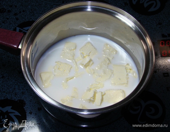 Пока бисквиты остывают, приготовим профитроли. Для этого смешать в сотейнике молоко, воду, соль, сахар и сливочное масло (комнатной температуры) и довести до кипения.