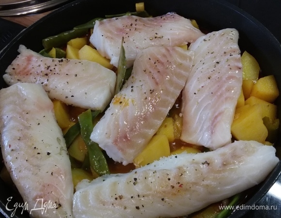 Когда картофель будет готов, выложить на овощи филе трески и готовить под крышкой 10–12 минут. Таким образом рыба как бы готовится на пару (пропитывается ароматом овощей и специй).