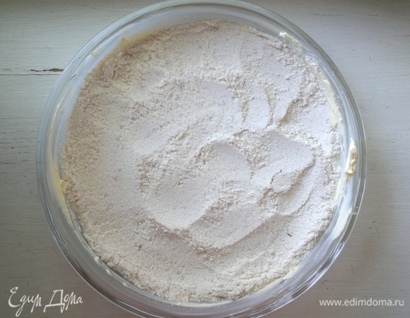 От общего количества сливочного масла взять кусочек 20 г. Смазать им дно и бока формы для выпечки (у меня диаметром 26 см). Затем насыпать в форму чуть больше половины сухой смеси.