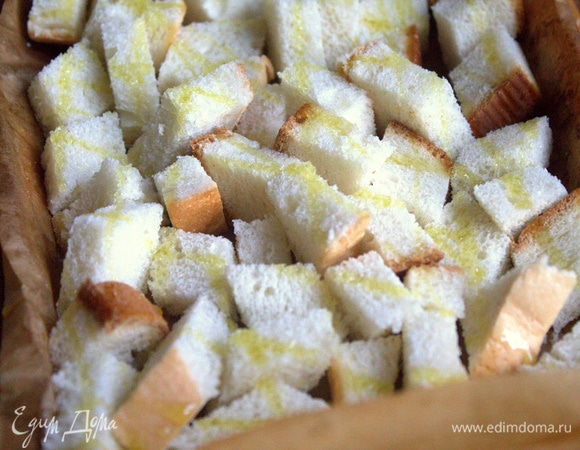 Обычный батон нарезать кубиками, сбрызнуть оливковым маслом.